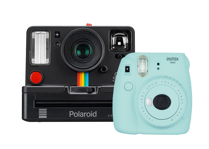 Czarna kamera Polaroid z tęczowym paskiem obok miętowego aparatu Instax Mini